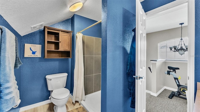 bathroom with lofted ceiling, toilet, a chandelier, a textured ceiling, and curtained shower