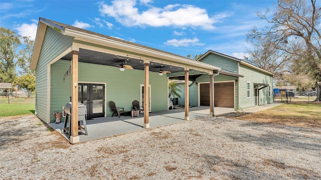 rear view of property featuring a garage, a patio, and ceiling fan