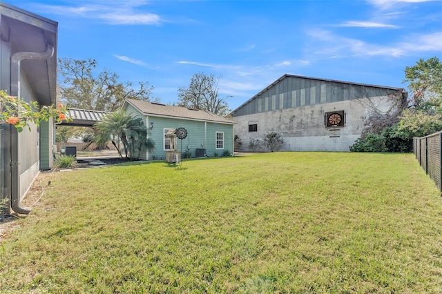 rear view of property with an outbuilding, central air condition unit, and a lawn