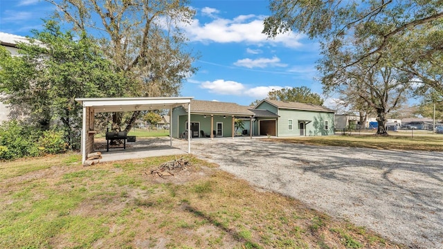 back of property with a yard and a carport