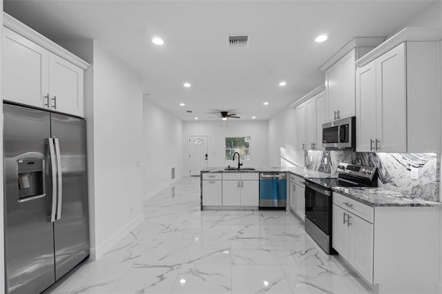 kitchen with sink, white cabinets, decorative backsplash, kitchen peninsula, and stainless steel appliances