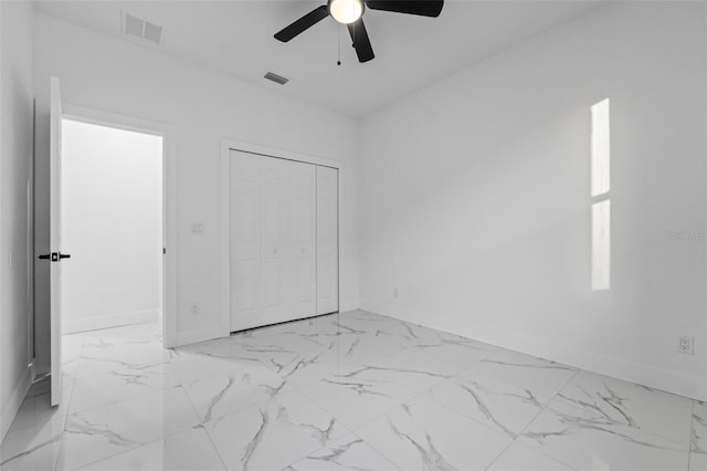 unfurnished bedroom with ceiling fan and a closet