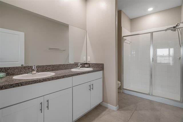 bathroom featuring tile patterned flooring, vanity, toilet, and walk in shower