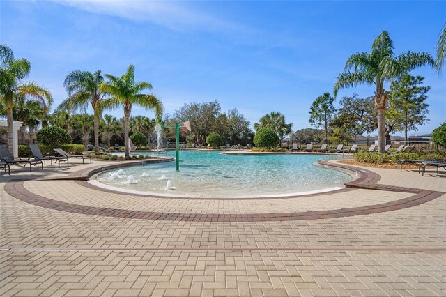 view of swimming pool with pool water feature and a patio area