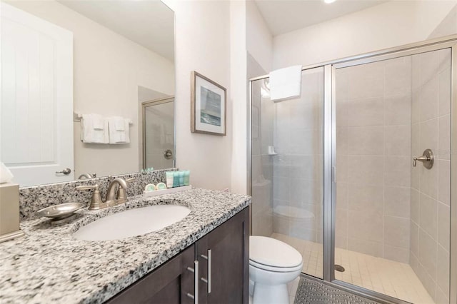 bathroom with vanity, an enclosed shower, and toilet