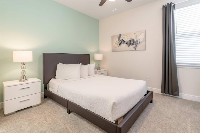 carpeted bedroom featuring multiple windows and ceiling fan