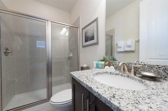 bathroom with vanity, toilet, and a shower with shower door