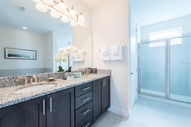 bathroom featuring tile patterned flooring, vanity, and a shower with door