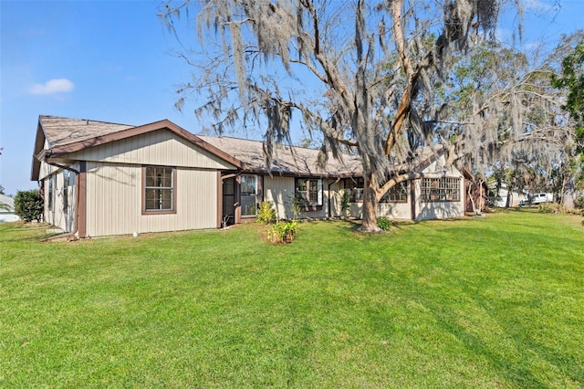 rear view of house featuring a yard