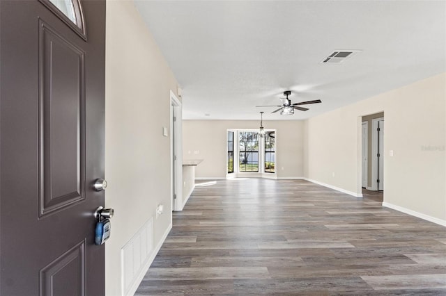 empty room with dark wood-type flooring and ceiling fan