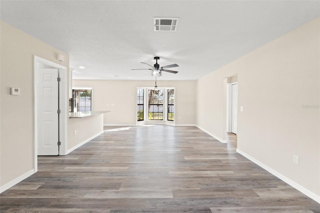 unfurnished living room featuring hardwood / wood-style flooring and ceiling fan