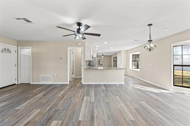 unfurnished living room with plenty of natural light, sink, and light wood-type flooring