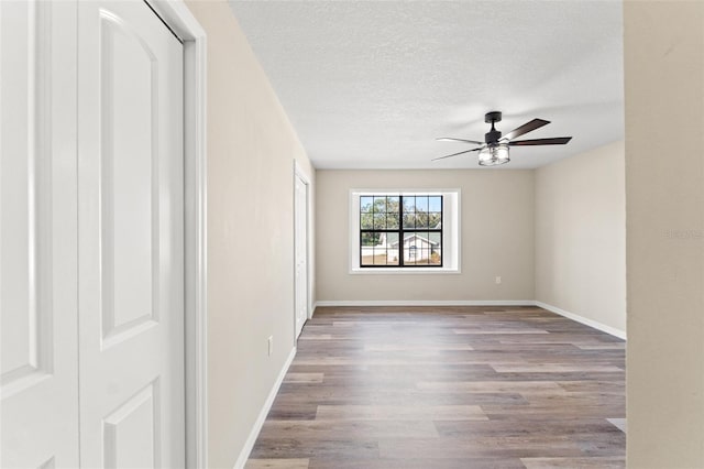 unfurnished room with ceiling fan, light hardwood / wood-style floors, and a textured ceiling