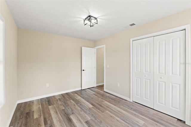 unfurnished bedroom featuring light hardwood / wood-style floors and a closet