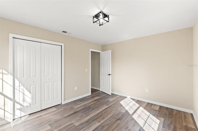 unfurnished bedroom with light hardwood / wood-style floors and a closet