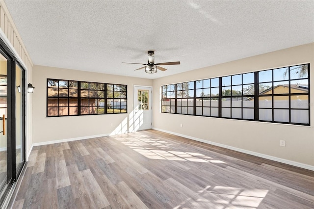 spare room with ceiling fan, a textured ceiling, and light wood-type flooring