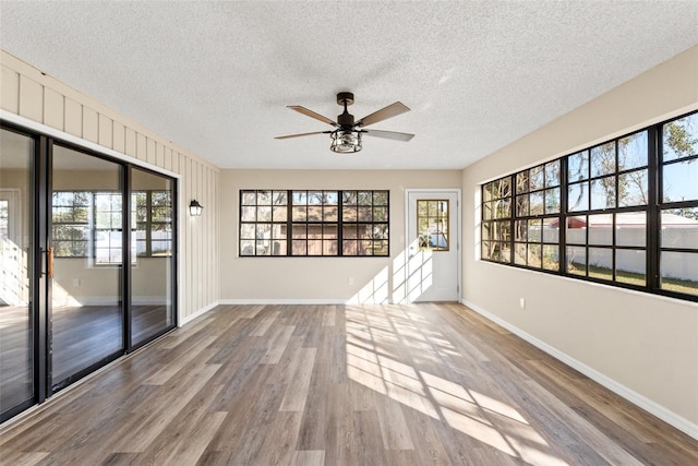 empty room featuring ceiling fan, a textured ceiling, and light wood-type flooring