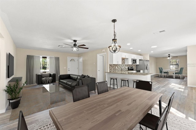 dining room with ceiling fan and light wood-type flooring