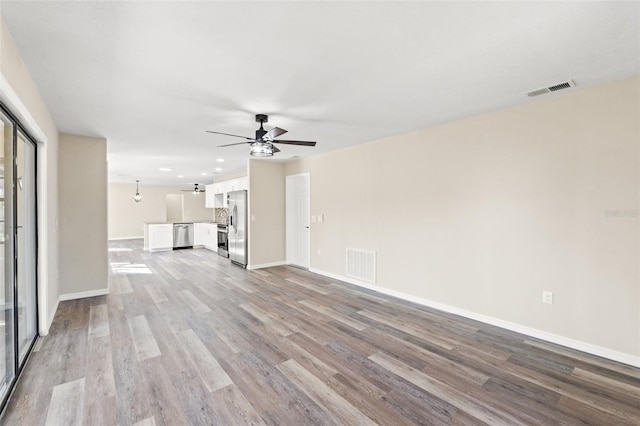 unfurnished living room featuring ceiling fan and light wood-type flooring