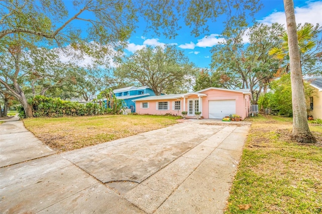 ranch-style home featuring a garage and a front lawn