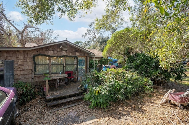 view of yard featuring a wooden deck and a sunroom