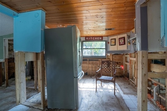 kitchen with stainless steel fridge and wood ceiling