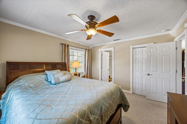 bedroom featuring crown molding, a textured ceiling, carpet floors, a closet, and ceiling fan