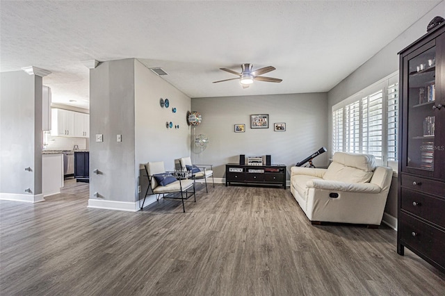 living room featuring ceiling fan, dark hardwood / wood-style floors, and a textured ceiling