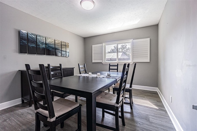 dining room with dark hardwood / wood-style floors and a textured ceiling