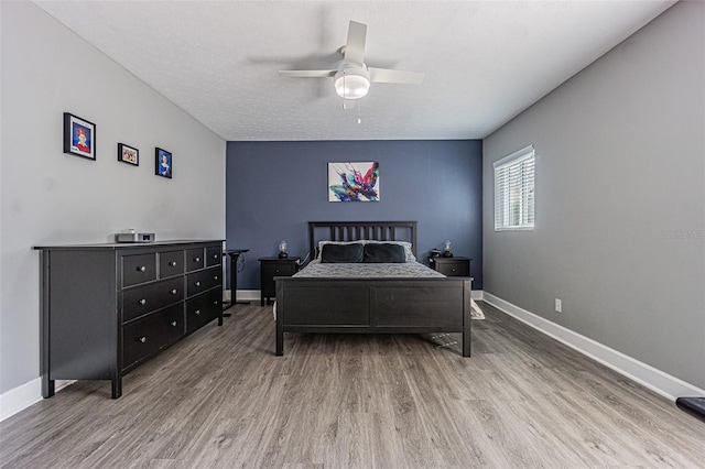 bedroom with wood-type flooring, a textured ceiling, and ceiling fan