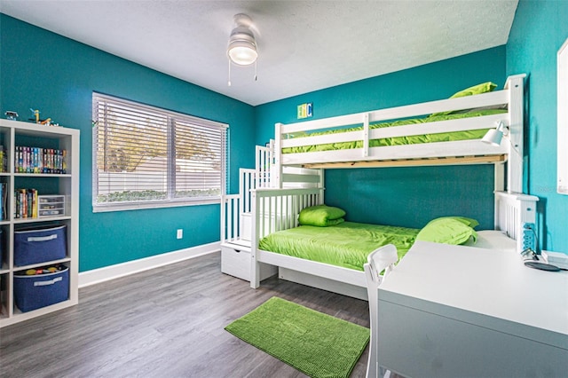 bedroom featuring hardwood / wood-style flooring, ceiling fan, and a textured ceiling