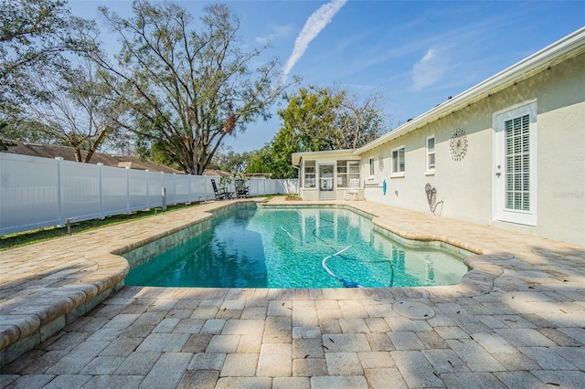 view of swimming pool with a patio and a sunroom