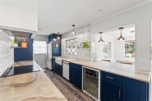 kitchen featuring blue cabinetry, high end fridge, hanging light fixtures, wine cooler, and black electric stovetop