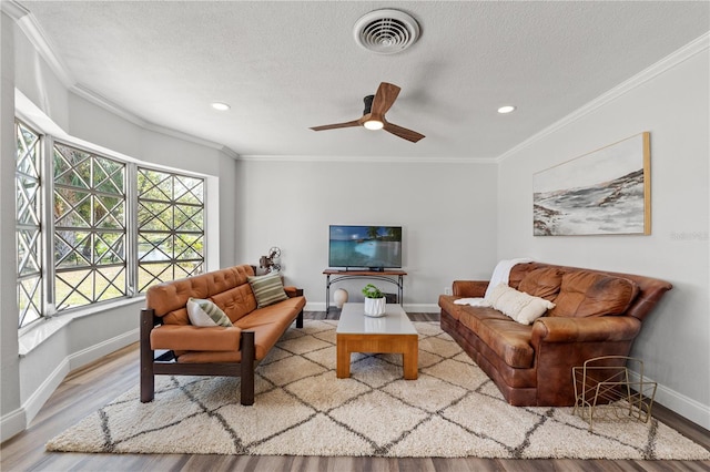 living room featuring crown molding, wood-type flooring, and a textured ceiling