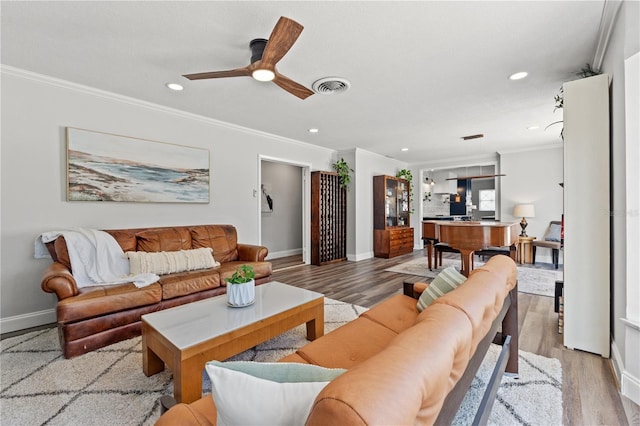 living room with crown molding, light hardwood / wood-style floors, and ceiling fan