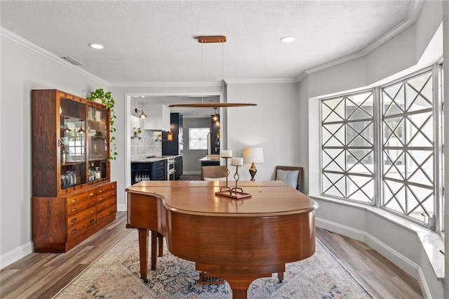 office featuring crown molding, light hardwood / wood-style flooring, and a textured ceiling