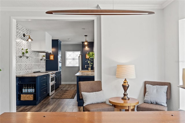 bar with blue cabinetry, appliances with stainless steel finishes, ornamental molding, and dark wood-type flooring