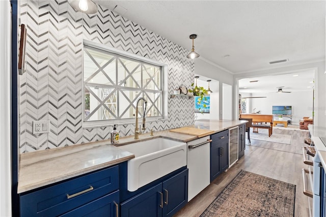 kitchen featuring wine cooler, blue cabinets, sink, hanging light fixtures, and dishwasher