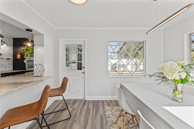 dining area with crown molding and hardwood / wood-style floors