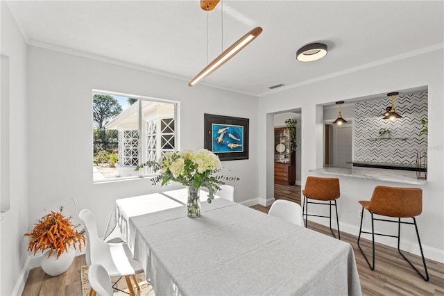 dining area featuring ornamental molding and hardwood / wood-style floors