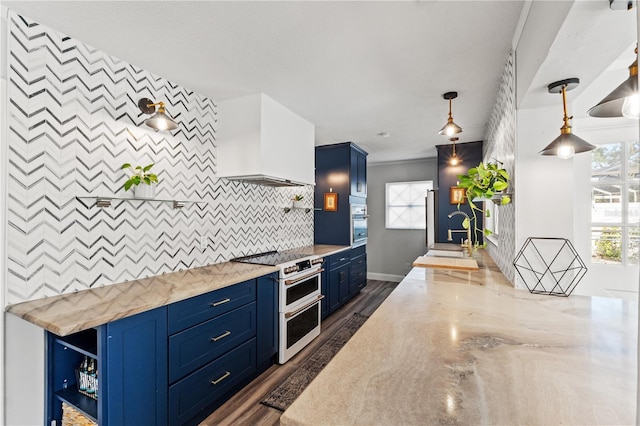 kitchen featuring premium range hood, sink, light stone counters, hanging light fixtures, and range with two ovens