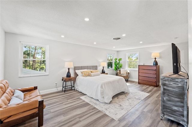 bedroom with a textured ceiling and light wood-type flooring