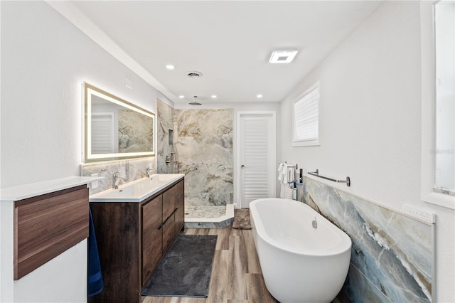 bathroom featuring tile walls, vanity, hardwood / wood-style flooring, and separate shower and tub