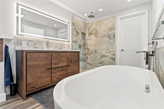 bathroom featuring vanity, hardwood / wood-style floors, and plus walk in shower