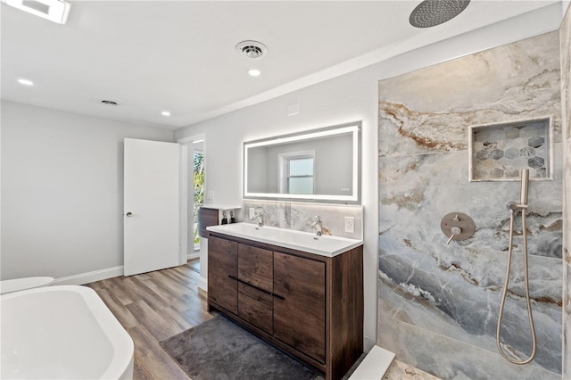 bathroom with vanity, wood-type flooring, and plus walk in shower