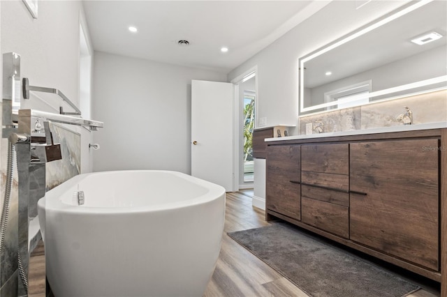 bathroom with vanity, hardwood / wood-style flooring, and a bathing tub