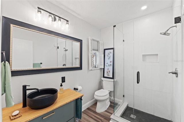 bathroom with vanity, hardwood / wood-style floors, toilet, and walk in shower