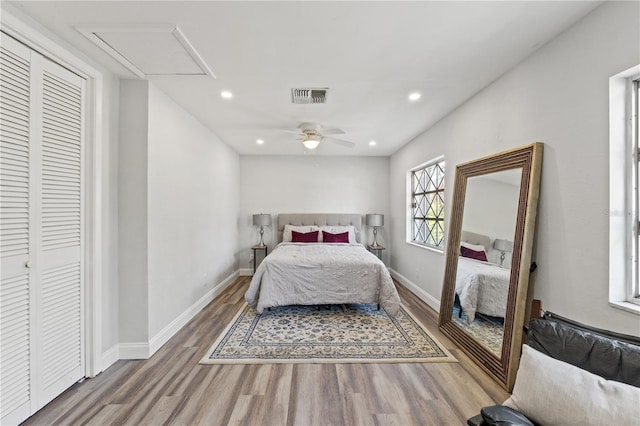 bedroom with wood-type flooring, ceiling fan, and a closet