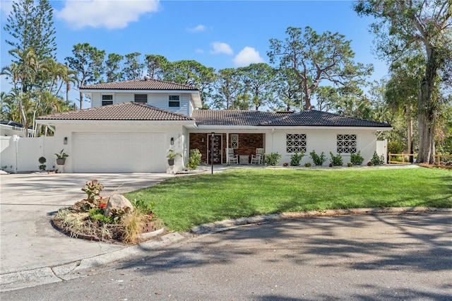 mediterranean / spanish home featuring a garage and a front yard