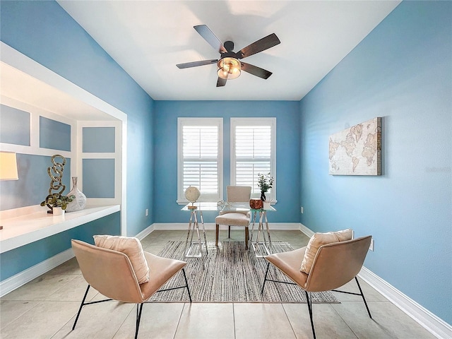 living area with ceiling fan and tile patterned floors